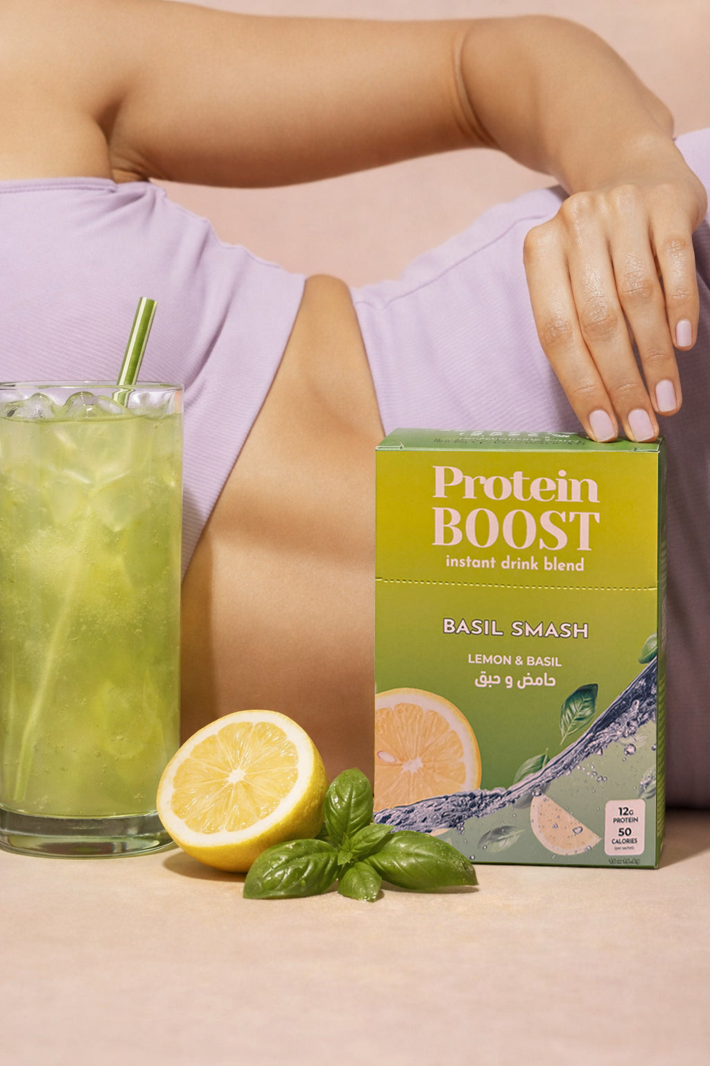 Protein Boost drink box Basil Lemonade Flavor with a glass of green juice and lemon on a beige background