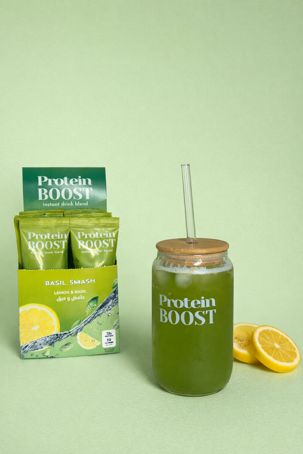 Protein Boost Basil Lemonade drink mix packaging with a jar of green juice and lemon slices on a light green background